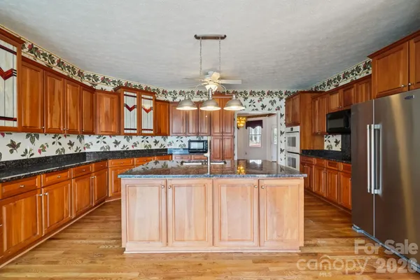 a kitchen with granite countertop a stove and cabinets