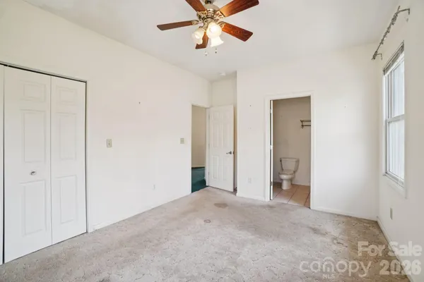 a view of a room with a ceiling fan and entryway