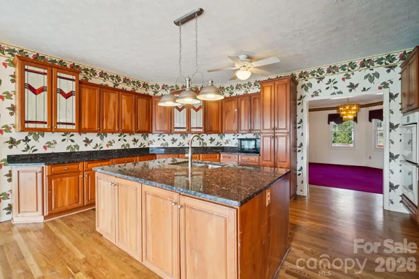 a kitchen with stainless steel appliances granite countertop a granite counter tops and a view of living room