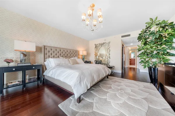 a bedroom with a large bed and a chandelier