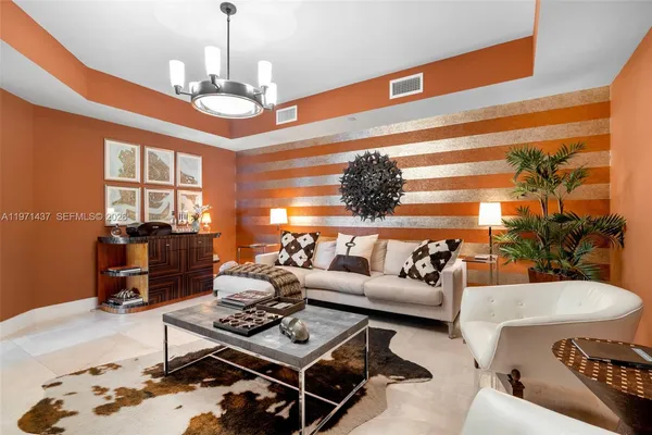 a living room with furniture a chandelier and a dining table