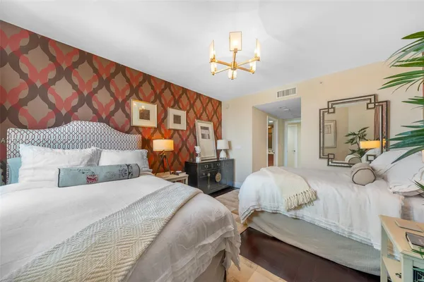 a bedroom with double bed and a chandelier
