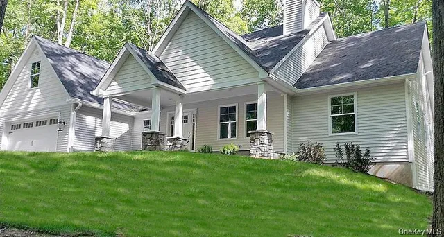 a view of a house with a yard and sitting area