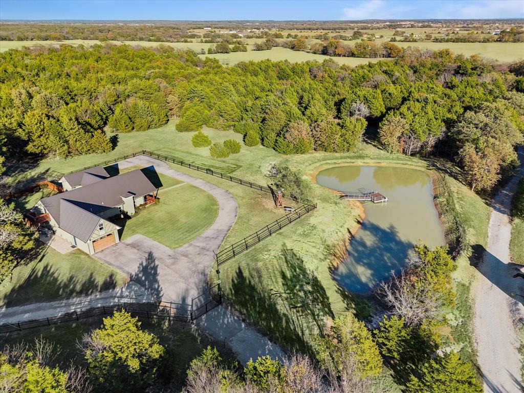 938 County Road 189 Gainesville, TX 76240 - Photo 1 of 1 Drone / aerial view with an abundance of trees and nice clearing around the home