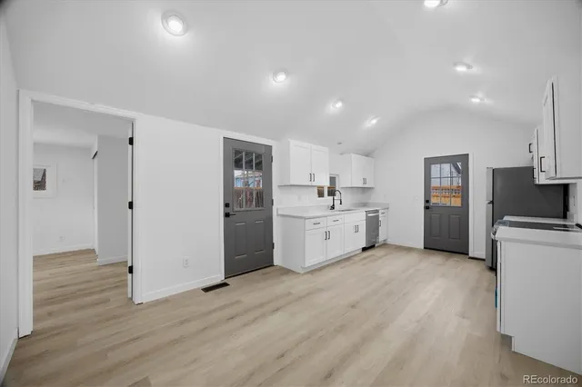 a view of a kitchen with refrigerator and wooden floor