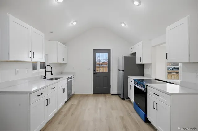 a kitchen with stainless steel appliances granite countertop a sink stove and refrigerator