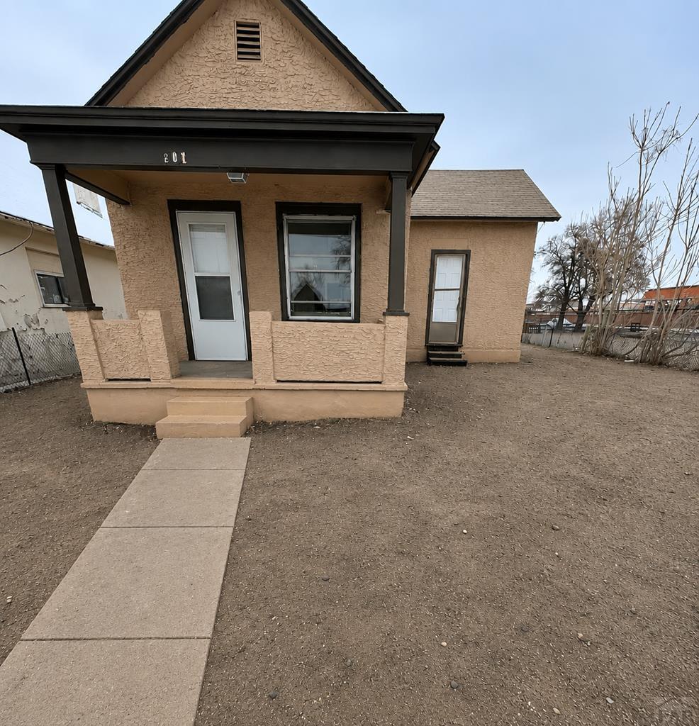 207 Spring Street Pueblo, CO 81003 - Photo 1 of 11 a view of a house with barbeque and wooden fence
