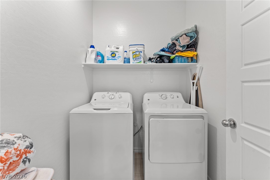 8879 Roadrunner Ravine Street Las Vegas, NV 89166 - Photo 33 of 39 A well-organized laundry area offers both a washer and dryer, complemented by convenient overhead shelving.