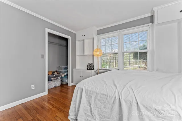 a bedroom with a bed and large windows