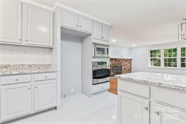 a kitchen with stainless steel appliances granite countertop a stove and a refrigerator
