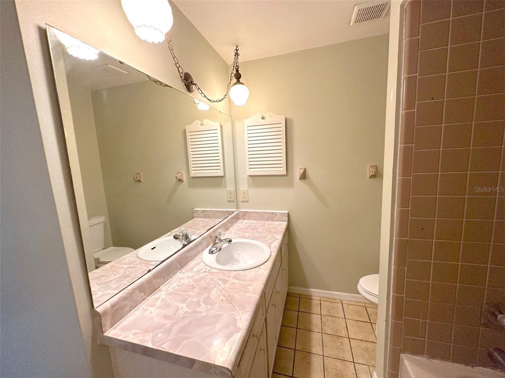 5061 Barnegat Point Road Orlando, FL 32808 - Photo 27 of 33 a bathroom with a sink a toilet a mirror and shower