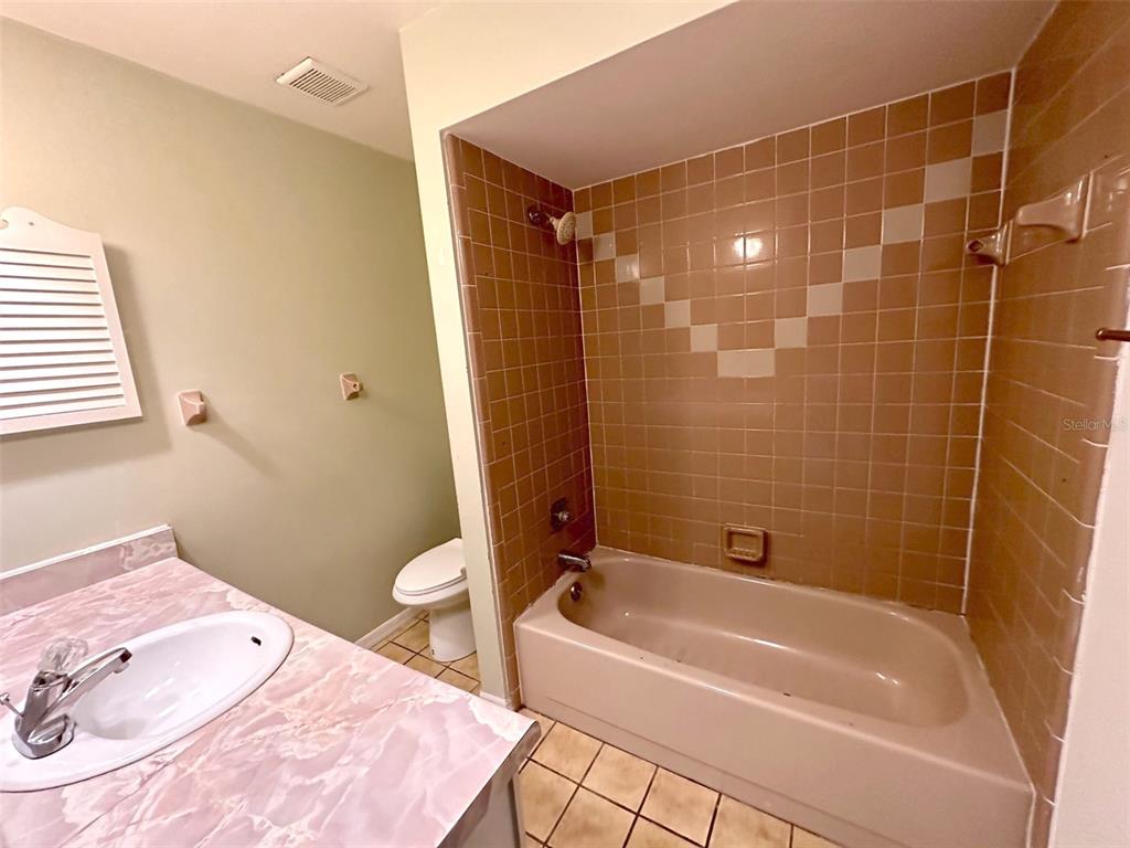 5061 Barnegat Point Road Orlando, FL 32808 - Photo 28 of 33 a bathroom with a tub shower sink and a toilet