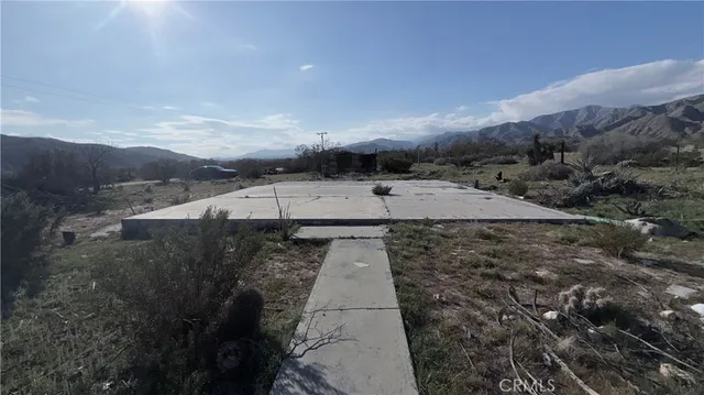an aerial view of a house with a yard and mountain view