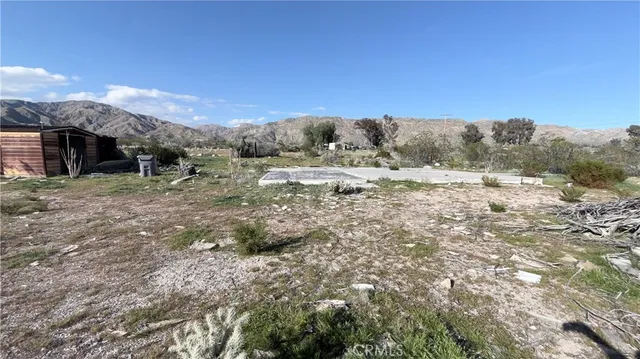 a view of a dry yard with mountains in the background