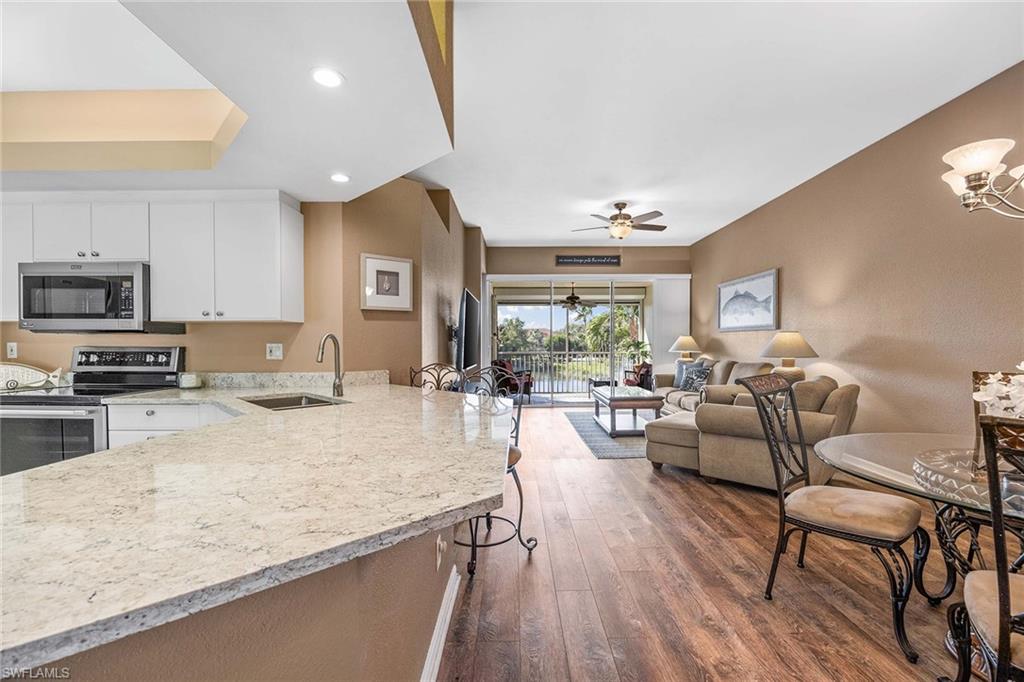 10801 Halfmoon Shoal Road, Unit 203 Estero, FL 34135 - Photo 3 of 50 a living room with furniture and a wooden floor