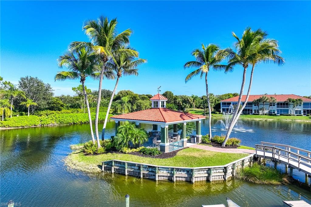 10801 Halfmoon Shoal Road, Unit 203 Estero, FL 34135 - Photo 42 of 50 a view of a lake with a table and chairs