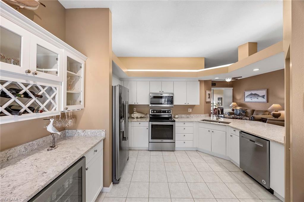 10801 Halfmoon Shoal Road, Unit 203 Estero, FL 34135 - Photo 5 of 50 a kitchen with stainless steel appliances granite countertop a sink and stove top oven