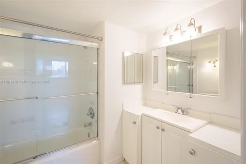 a bathroom with a bathtub shower sink and mirror