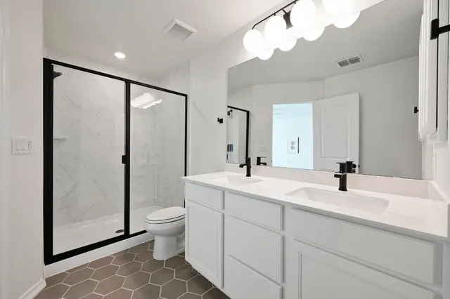 a bathroom with a double vanity sink mirror and toilet