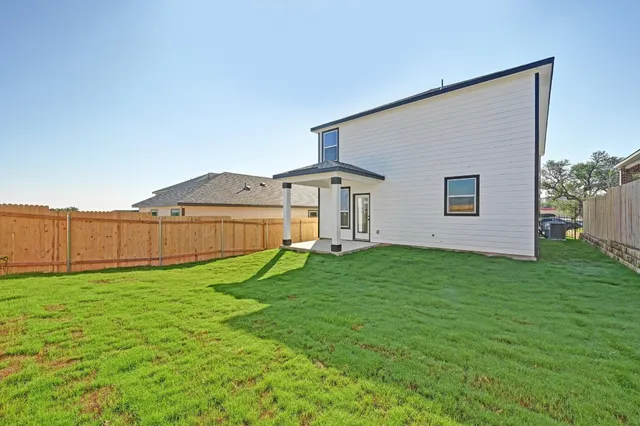 a view of a backyard with potted plants and wooden fence