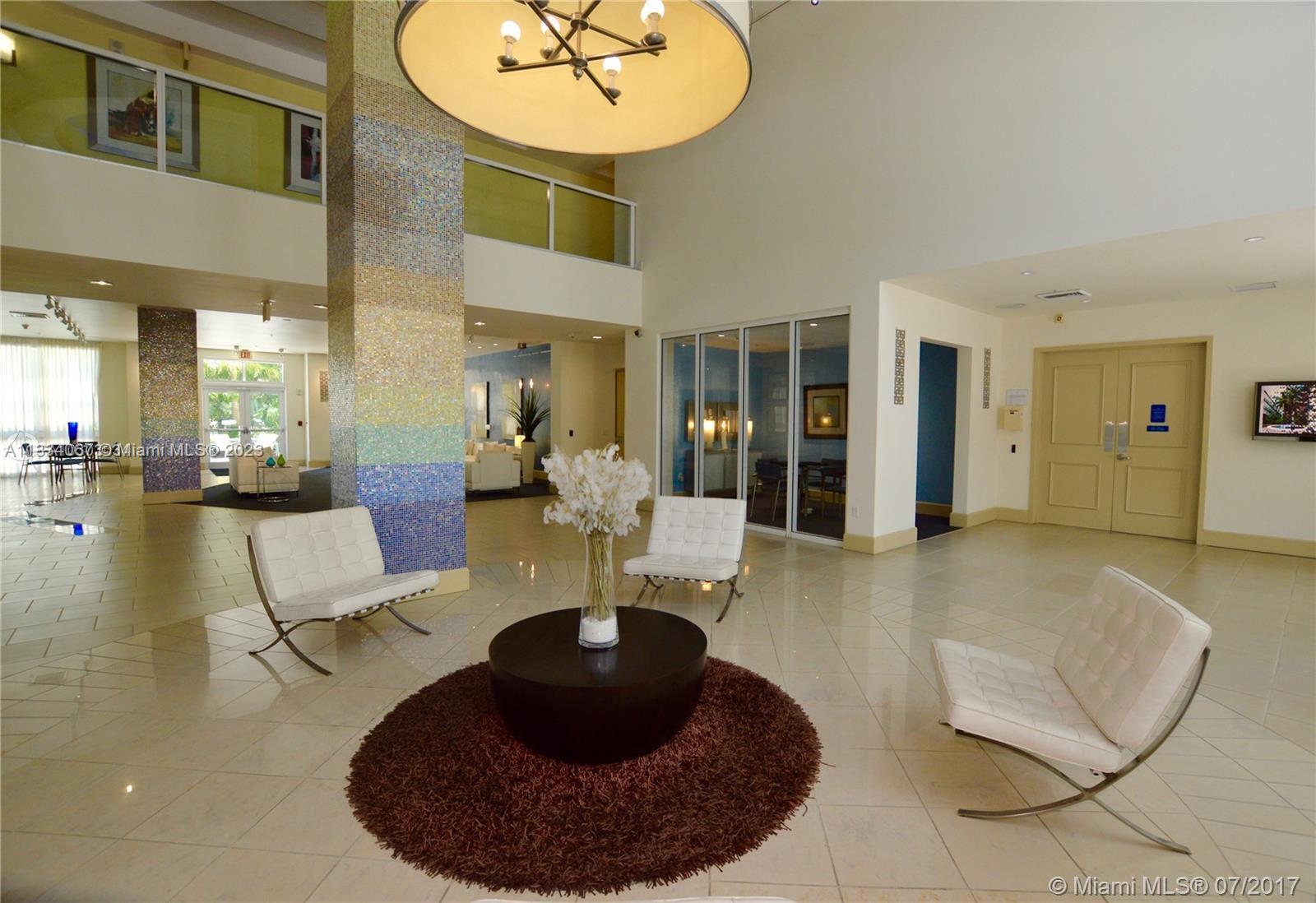 2001 Biscayne Boulevard, Unit 2503 Miami, FL 33137 - Photo 17 of 22 a living room with furniture and a chandelier