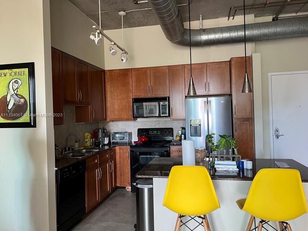 2001 Biscayne Boulevard, Unit 2503 Miami, FL 33137 - Photo 7 of 22 a kitchen with stainless steel appliances a stove a refrigerator and cabinets