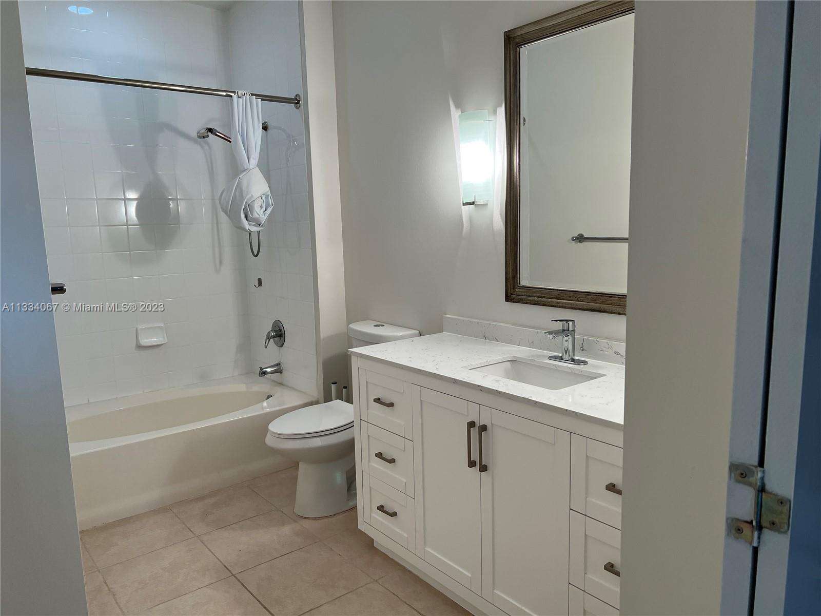 2001 Biscayne Boulevard, Unit 2503 Miami, FL 33137 - Photo 8 of 22 a bathroom with a granite countertop sink toilet and shower