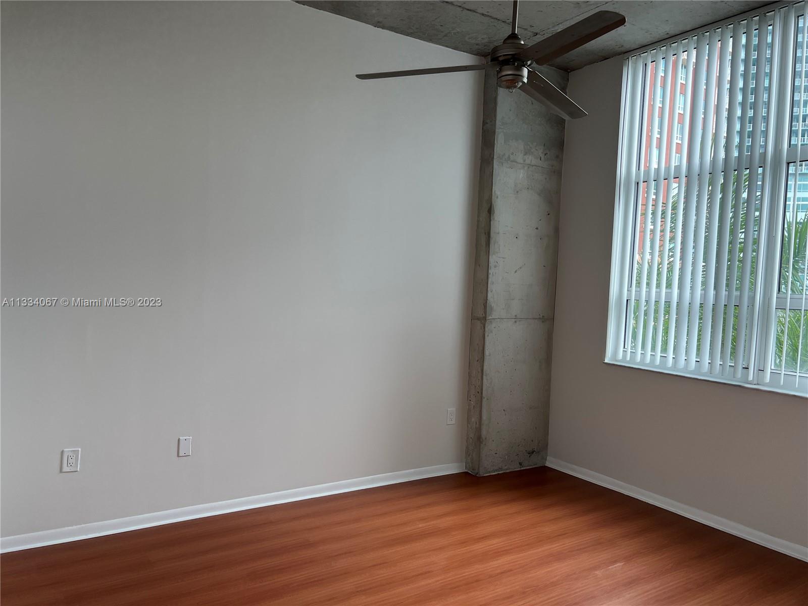 2001 Biscayne Boulevard, Unit 2503 Miami, FL 33137 - Photo 10 of 22 an empty room with wooden floor and windows