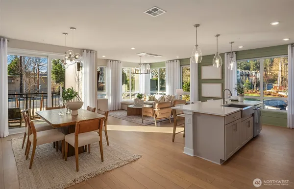a living room with stainless steel appliances granite countertop furniture and a wooden floor