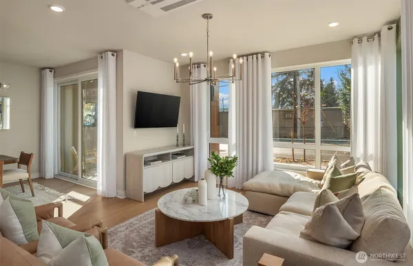 a living room with furniture a flat screen tv and a large window