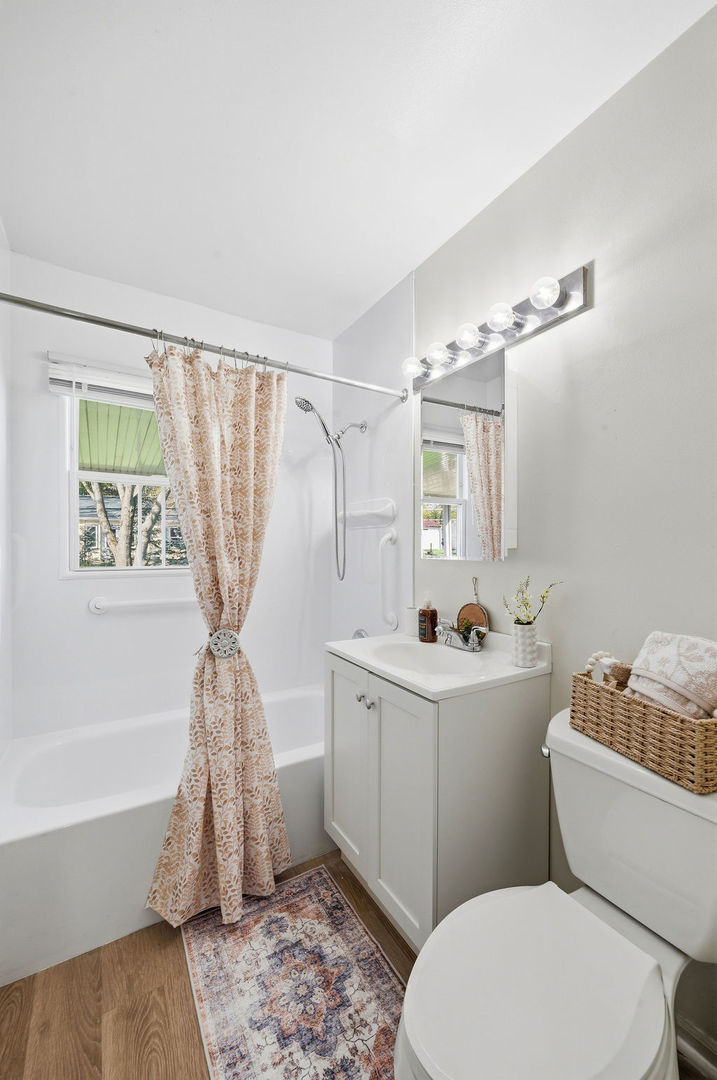 910 Meadow Lane Streamwood, IL 60107 - Photo 23 of 30 a bathroom with a sink a toilet a mirror and bathtub
