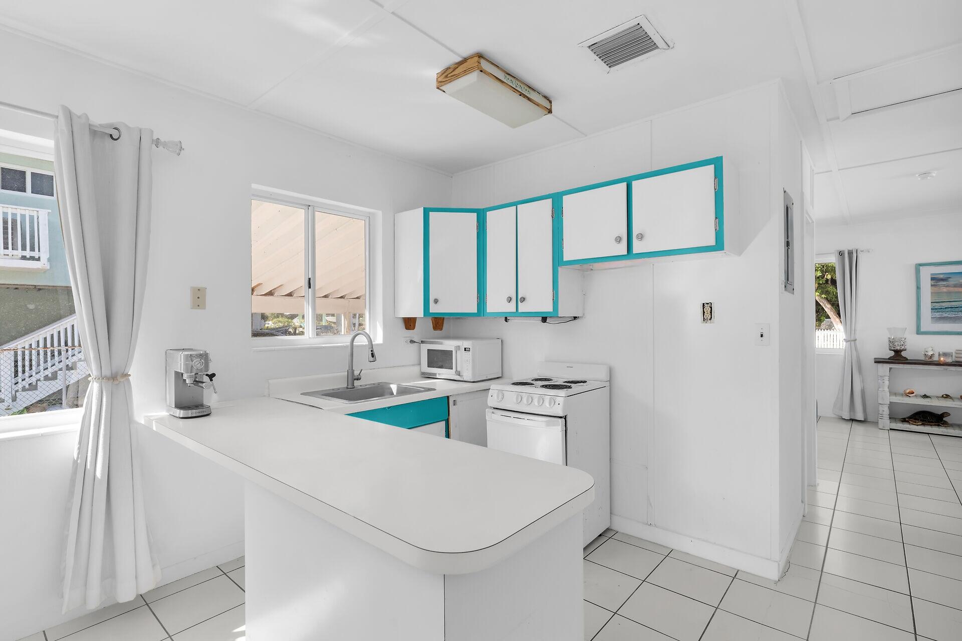 20 Palm Drive Key Largo, FL 33037 - Photo 19 of 47 a kitchen with white cabinets and appliances