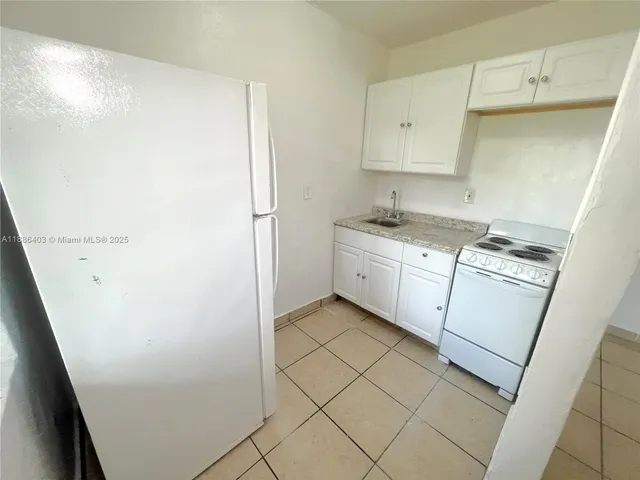 a kitchen with a sink a stove and cabinets
