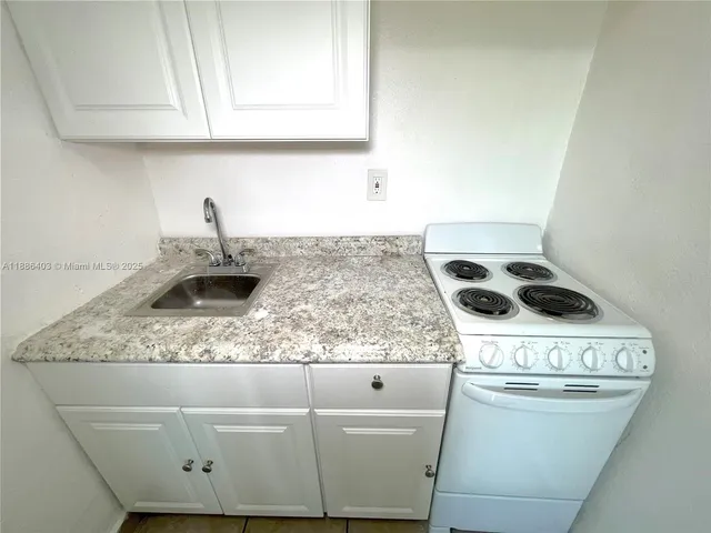 a kitchen with a stove and a white refrigerator