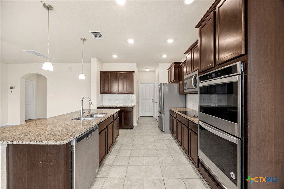 5927 Galveston Road Belton, TX 76513 - Photo 12 of 39 a large kitchen with granite countertop a sink and a stove top oven