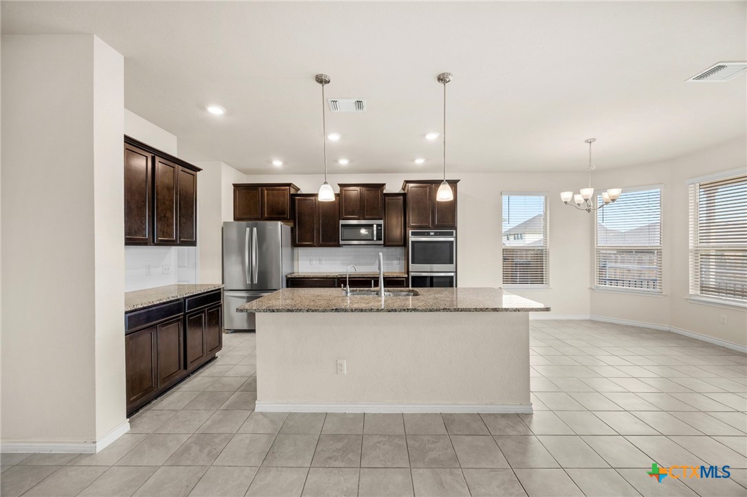 5927 Galveston Road Belton, TX 76513 - Photo 13 of 39 a large kitchen with stainless steel appliances kitchen island granite countertop a large counter top and a stove