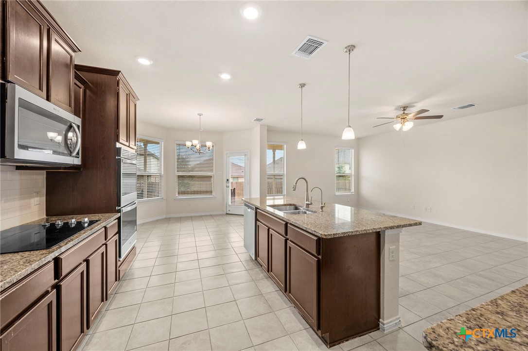 5927 Galveston Road Belton, TX 76513 - Photo 10 of 39 a kitchen with stainless steel appliances granite countertop a stove a sink dishwasher and a refrigerator with wooden floor