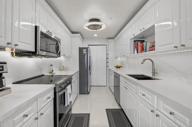 a kitchen with stainless steel appliances granite countertop a sink stove and cabinets