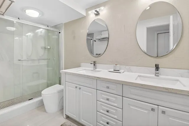 a bathroom with a double vanity sink mirror and toilet