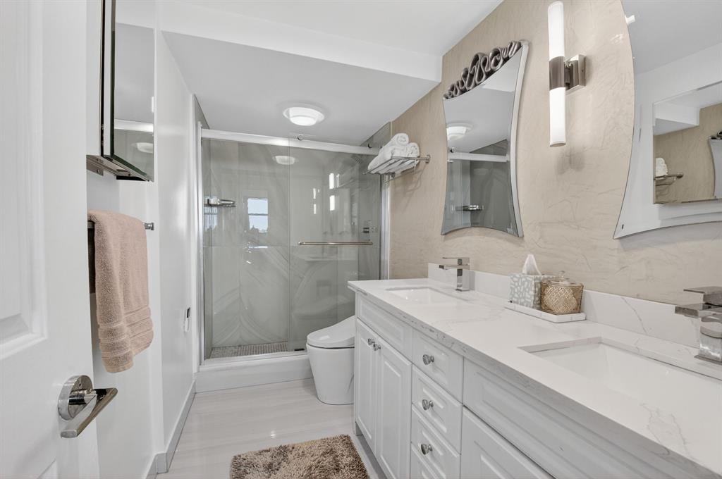899 Jeffery Street, Unit 710 Boca Raton, FL 33487 - Photo 17 of 44 a bathroom with a double vanity sink toilet mirror and shower