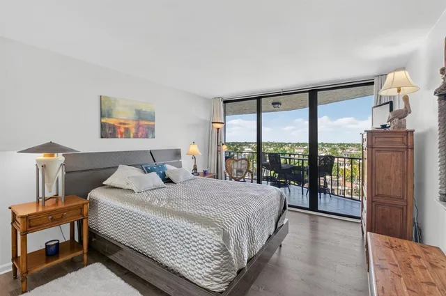 a bedroom with a bed and large windows