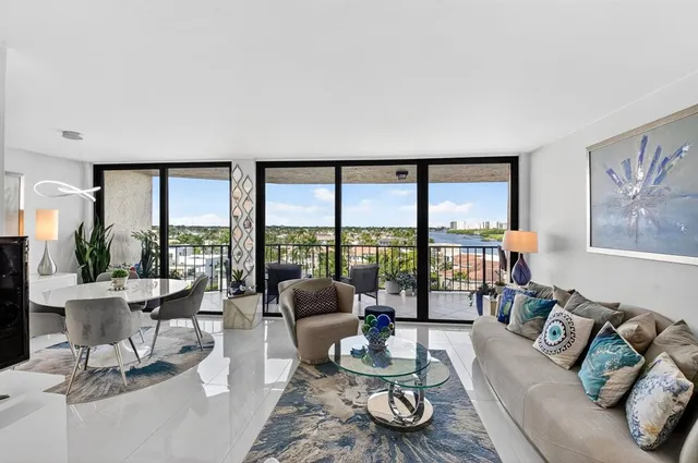 a living room with furniture and floor to ceiling windows