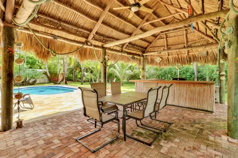 a view of pool with lawn chairs and plants