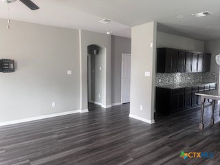 861 Stockdale Road Copperas Cove, TX 76522 - Photo 6 of 35 a view of an empty room with wooden floor and a kitchen