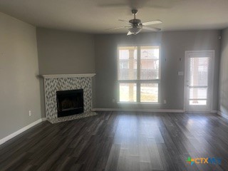 861 Stockdale Road Copperas Cove, TX 76522 - Photo 7 of 35 an empty room with wooden floor a chandelier fan and a fireplace