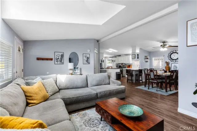 a living room with furniture kitchen view and a large window