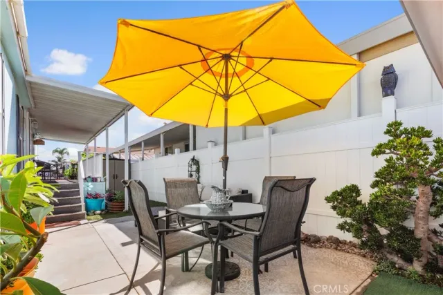 a view of a patio with table and chairs under an umbrella