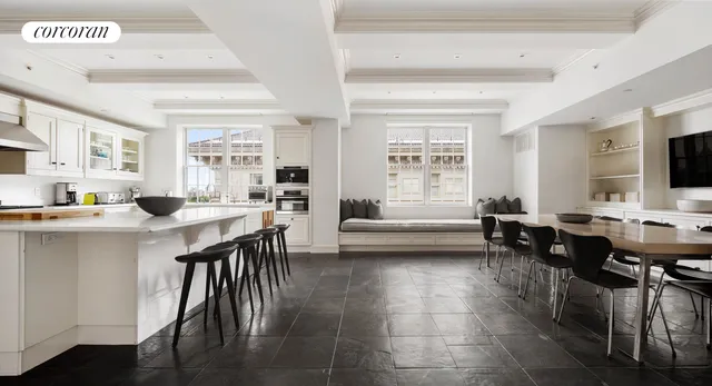 a living room with couches a flat tv screen and a dining table with wooden floor