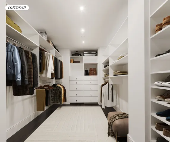 a view of walk in closet with clothes and shoes