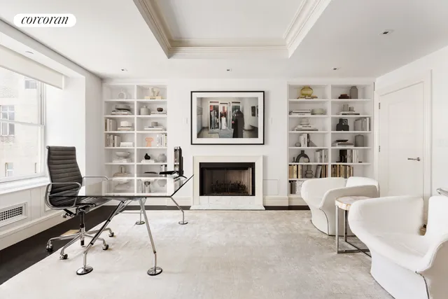 a living room with furniture a fireplace and a large window